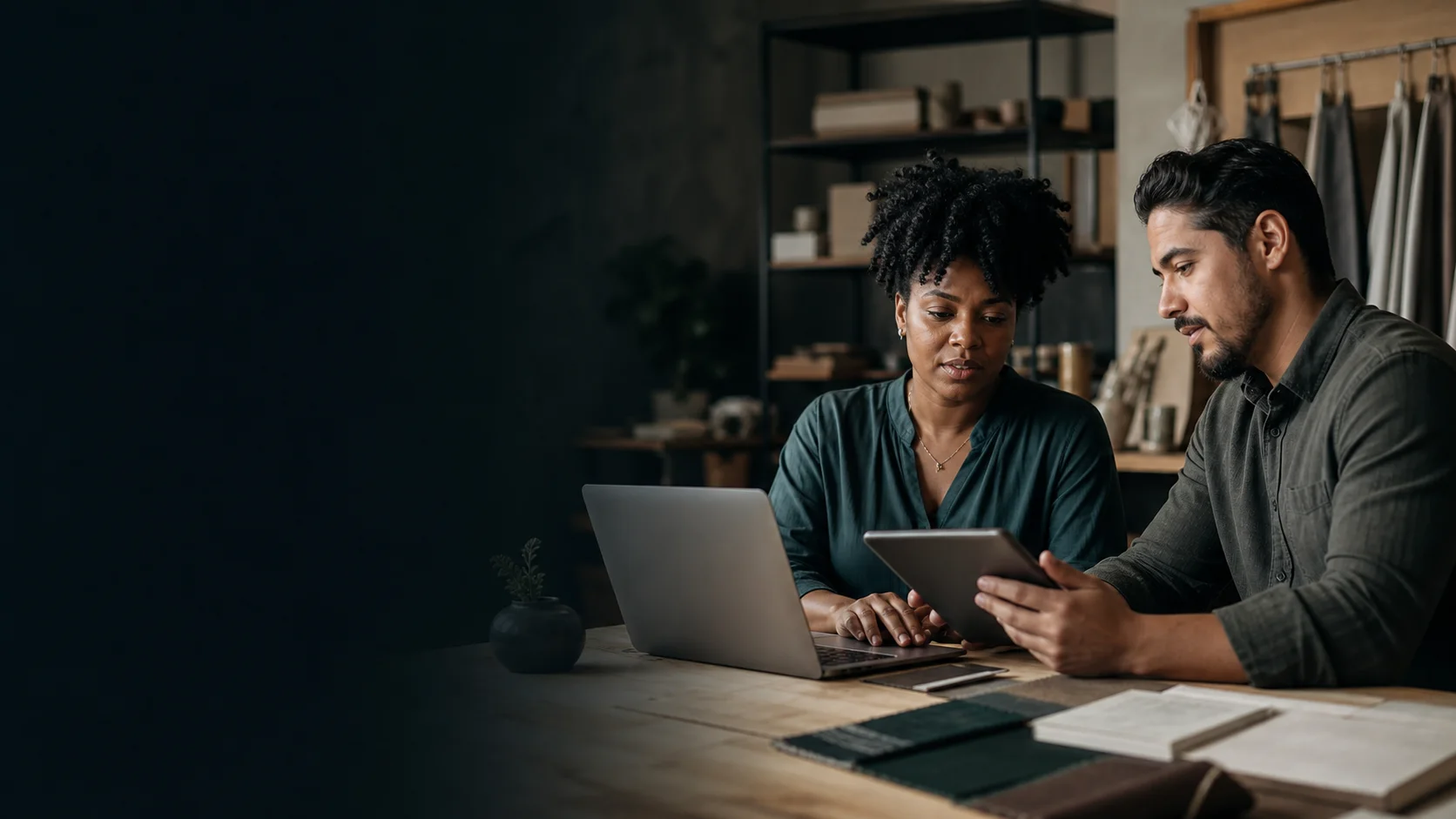 Small-business owner and web professional reviewing a website together on a laptop and tablet