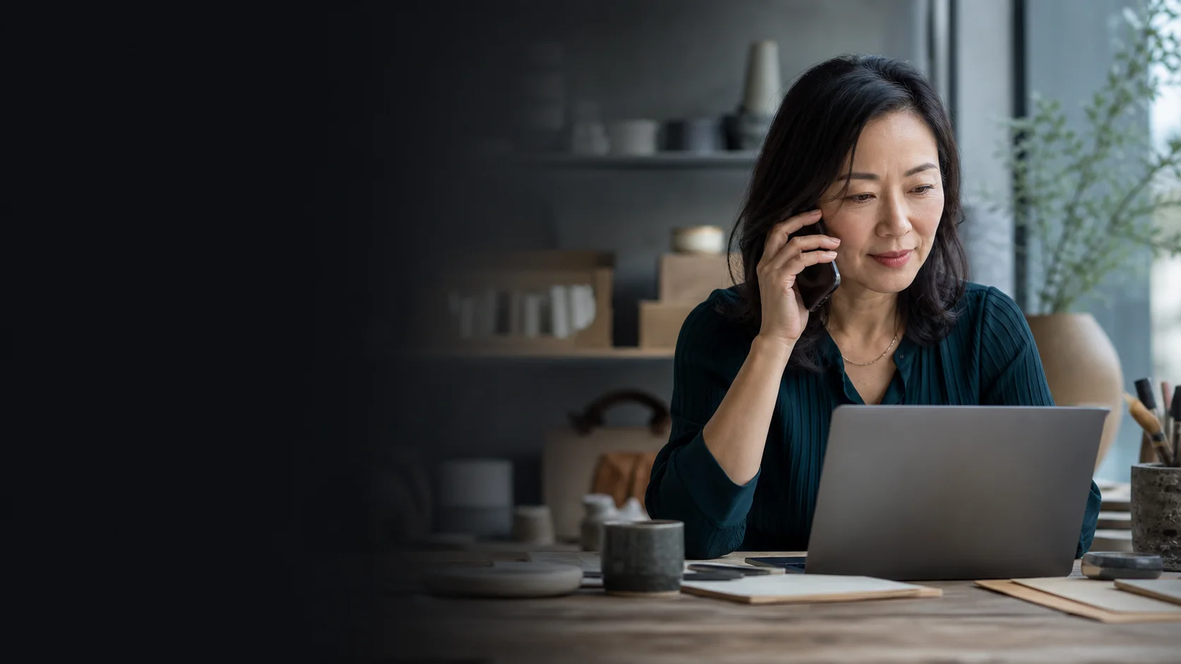 Local business owner calling while reviewing her website on a laptop